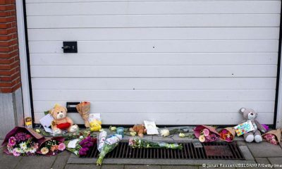 Agujeros de bala y flores con mensajes de condolencia frente al garaje de una casa de Amberes donde fue asesinada una niña por disparos de narcotraficantes. Foto: DW