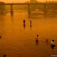 Personas vadean en el río bajo un cielo enrarecido por el denso humo de los incendios forestales, en Renaico. Foto: DW