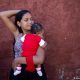 Una adolescente venezolana sostiene en brazos a su bebé en las afueras de una clínica de Caracas. Foto: DW