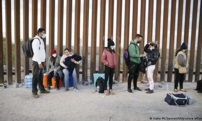 Migrantes procedentes de India, Cuba y Colombia esperan en Yuma, Arizona, junto a la valla fronteriza entre México y EE.UU. Foto: DW.