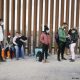 Migrantes procedentes de India, Cuba y Colombia esperan en Yuma, Arizona, junto a la valla fronteriza entre México y EE.UU. Foto: DW.