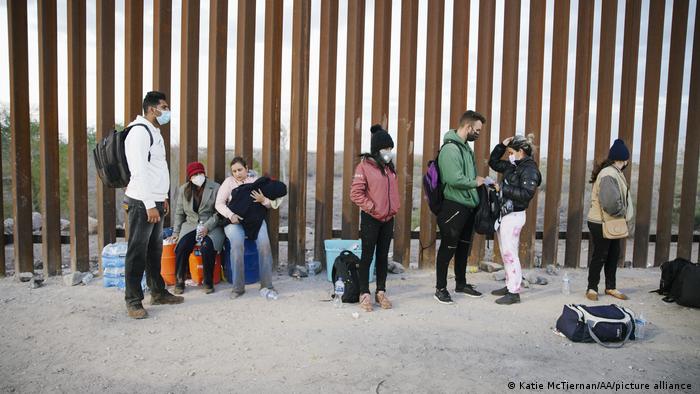 Migrantes procedentes de India, Cuba y Colombia esperan en Yuma, Arizona, junto a la valla fronteriza entre México y EE.UU. Foto: DW.