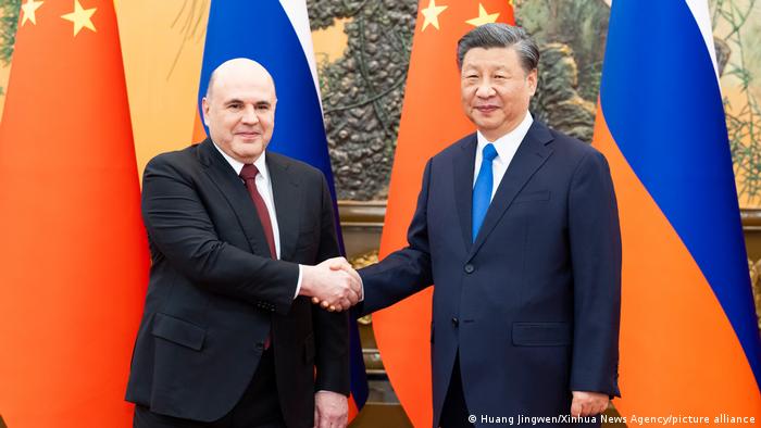 El presidente chino, Xi Jinping (der.), junto al primer ministro ruso, Mijail Mishustin. Foto: DW.