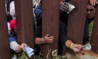 Migrantes buscan pagar a vendedores de comida del otro lado del muro. Foto: Infobae.