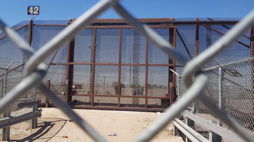 Unas personas esperan en el lado mexicano frente a la puerta 42, hoy en la frontera estadounidense de El Paso, Texas (EE.UU.). EFE/Jorge Fuentelsaz.