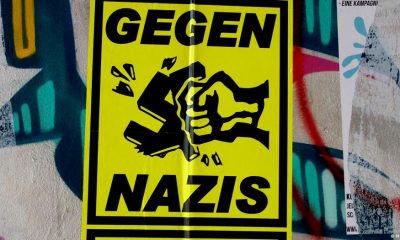 Un cartel pegado sobre un graffiti en la pared de una vivienda en Berlín expresa el rechazo al fascismo, la extrema derecha y los nazis. Foto: DW.