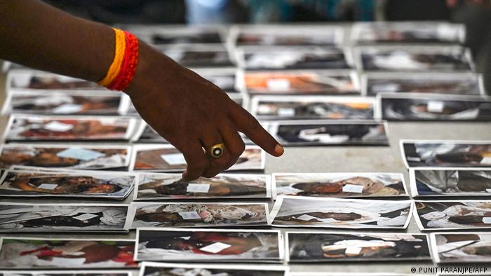 Imagenes de los rostros de las víctimas expuestas en una mesa para su reconocimiento. Foto: DW.