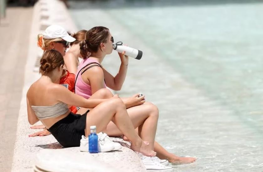 Varios turistas intentan refrescarse en la Ciudad de las Artes y las Ciencias durante la ola de calor en Valencia, España. Foto: Infobae.