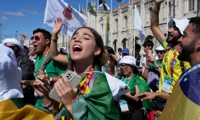 Jóvenes peregrinos brasileños cantan y bailan frente al monasterio de los Jerónimos en Lisboa, el martes 1 de agosto de 2023. Foto: DW.