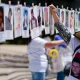 Una mujer cuelga un retrato de una persona desaparecida en un memorial improvisada a lo largo de la Avenida Reforma de Ciudad de México, en el Día Internacional de las Víctimas de Desapariciones Forzadas. Foto. DW.