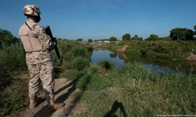 Un soldado dominicano vigila desde la orilla del río Masacre, una frontera natural con Haití. Foto: DW.