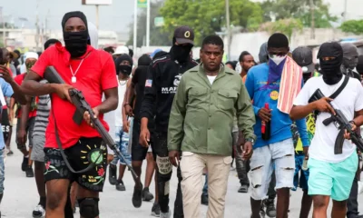 Jimmy Chérizier "Barbecue", líder de la Familia G9, camina por las calles de Puerto Príncipe junto a otros miembros de su banda y armados con fusiles y metralletas. Foto: DW.