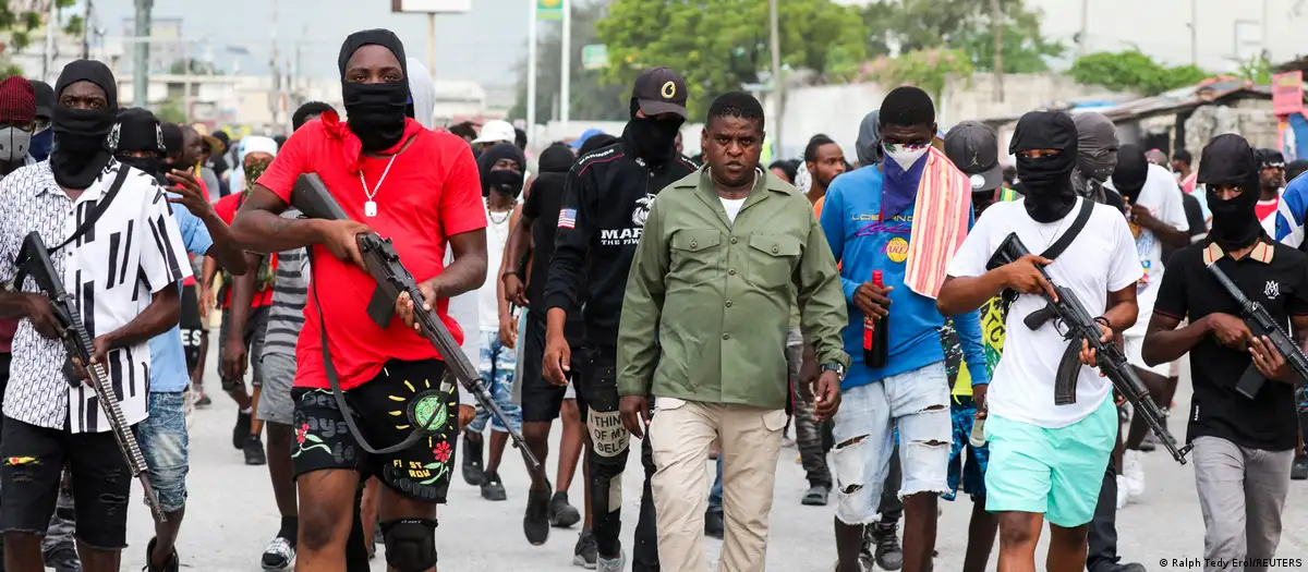 Jimmy Chérizier "Barbecue", líder de la Familia G9, camina por las calles de Puerto Príncipe junto a otros miembros de su banda y armados con fusiles y metralletas. Foto: DW.