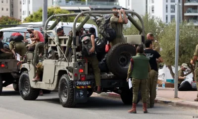 Reservistas israelíes se suben a vehículos de transporte militar camino a sus bases el pasado sábado en Tel Aviv. Foto: DW.