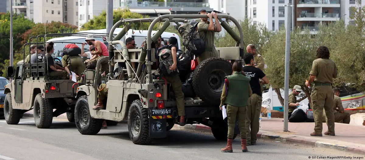 Reservistas israelíes se suben a vehículos de transporte militar camino a sus bases el pasado sábado en Tel Aviv. Foto: DW.