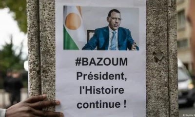 Cartel del presidente derrocado Mohamed Bazoum colgado en una pared frente a la embajada de Niger en París. Foto: DW.