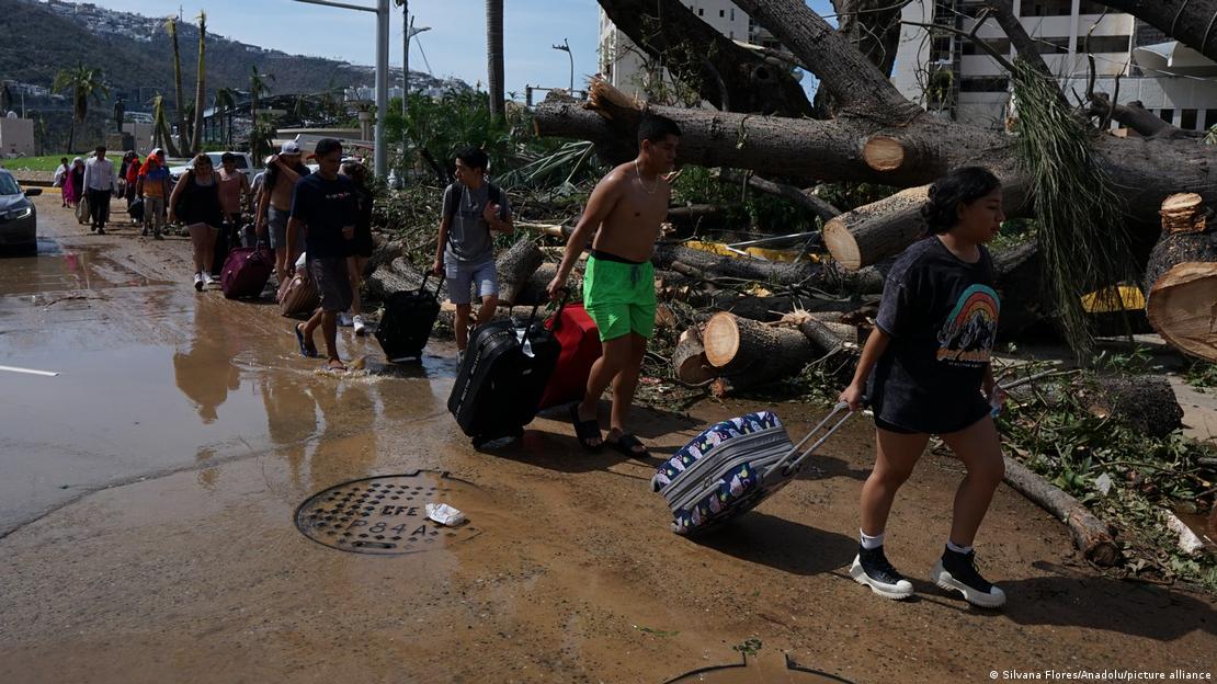 Personas abandonan la zona severamente dañada por el huracán. Foto: DW.