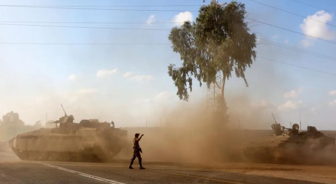 Vehículos blindados de transporte de tropas israelíes maniobran en una zona de la frontera con Gaza, al sur de Israel. EFE/ Abir Sultan/El País.