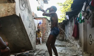 Un adolescente se baña con agua recogida de una tubería en Complexo da Mare, uno de los complejos de favelas más grandes de Río de Janeiro. Foto: DW.