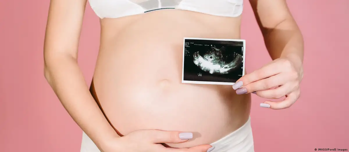 Mujer embarazada muestra una imagen de su ultrasonido. Foto referrencial. DW.