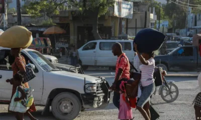 Personas desplazadas de sus hogares debido a enfrentamientos entre bandas armadas en Cité Soleil, caminan por una calle del barrio de Tabarre mientras buscan refugio en Puerto Príncipe. Foto: DW.