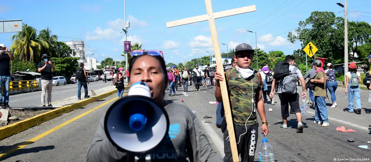 Una mujer dirige una "caravana" de migrantes centroamericanos/as por una vía de Chiapas, sur de México. Foto: DW.