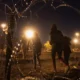 Migrantes cruzan un hueco en una valla de serpentina metálica, cerca del muro fronterizo entre México y Estados Unidos en El Paso, Texas. Fuente: DW. Archivo.