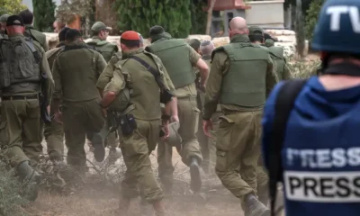 Imagen referencial: un periodista toma fotos de soldados israelíes en un kibutz. DW.