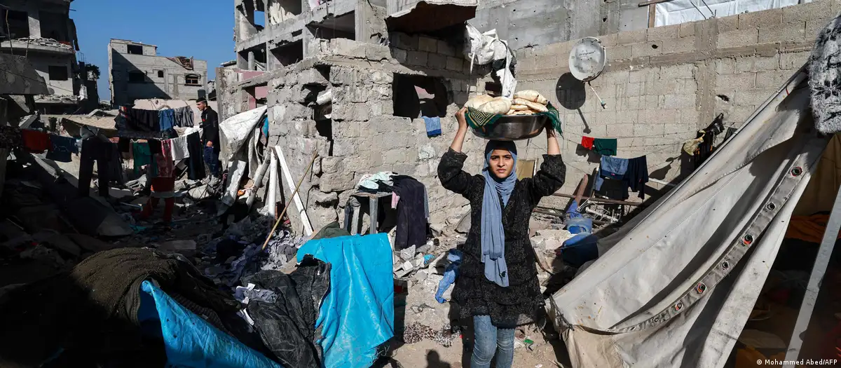 Una mujer carga pan en Rafah. Foto: DW.