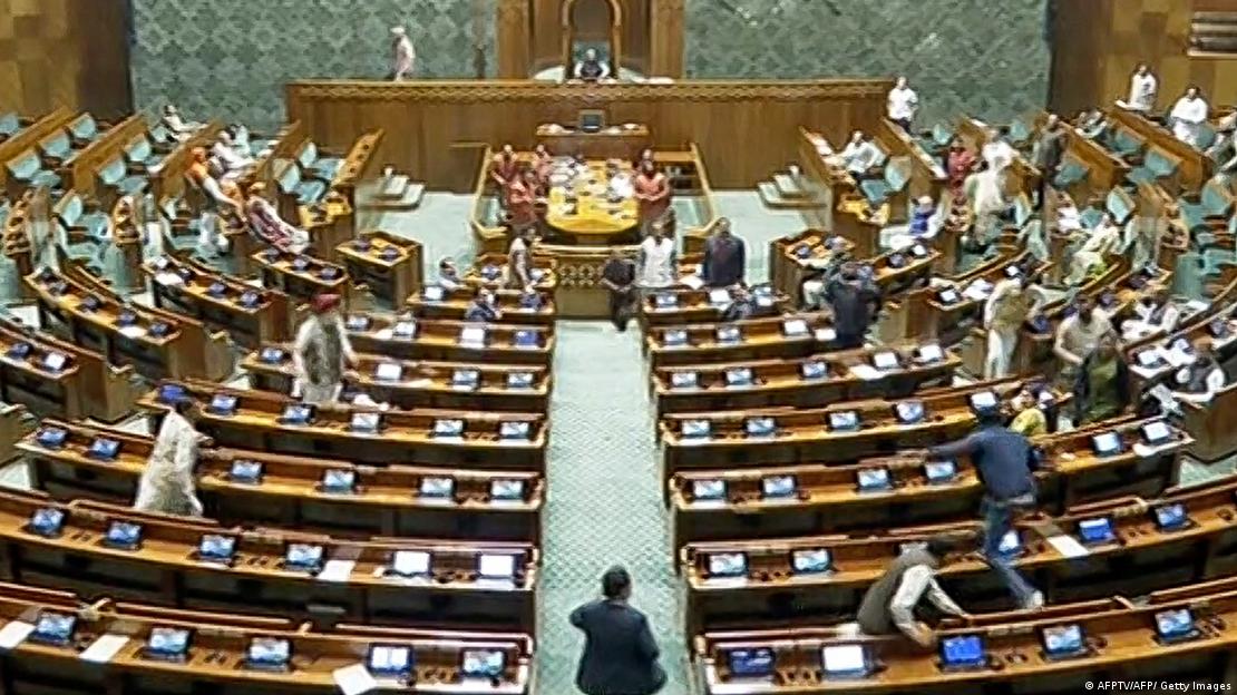 Un hombre salta sobre los bancos del Parlamento indio, en Nueva Delhi. Foto: DW.