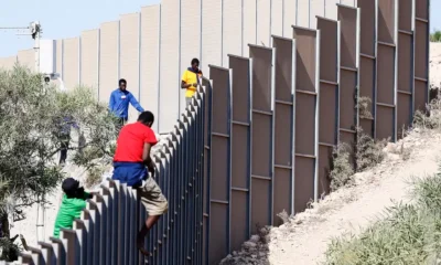 Migrantes trepan una cerca en Lampedusa. Foto: DW.