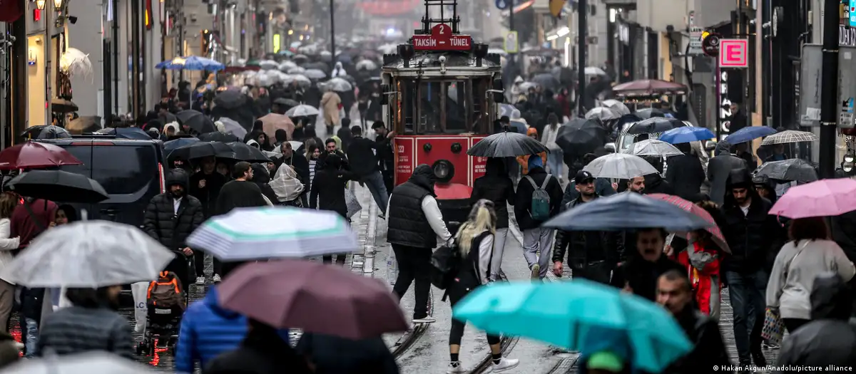 Turistas y ciudadanos caminan con paraguas en la calle Istiklal durante una lluvia en Estambul. Desde el mortal atentado contra la discoteca Reina en Estambul en la nochevieja de 2016, las autoridades turcas extreman la vigilancia en estas fechas. Foto: DW.