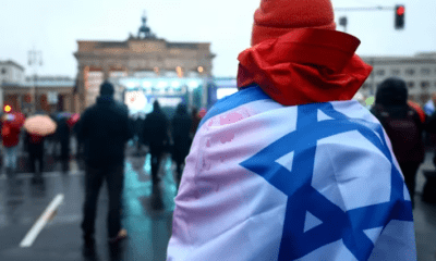 Una persona con l bandera de Israel en una protesta contra el antisemitismo. Foto: Infobae.