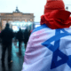 Una persona con l bandera de Israel en una protesta contra el antisemitismo. Foto: Infobae.