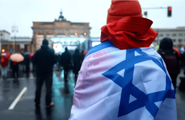 Una persona con l bandera de Israel en una protesta contra el antisemitismo. Foto: Infobae.