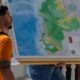 Un hombre carga un mapa del Esequibo. Foto: DW.