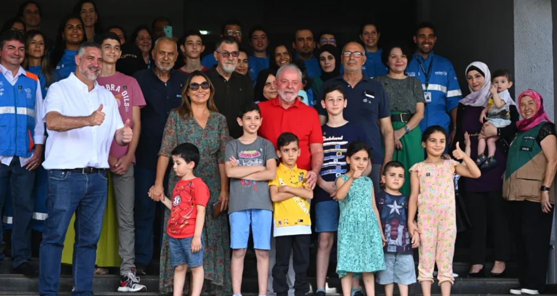 El presidente de Brasil, Luiz Inácio Lula da Silva (c), posa con personas repatriadas de la Franja de Gaza en un almuerzo hoy, en la Base Aérea Militar de Brasilia (Brasil). EFE/Andre Borges