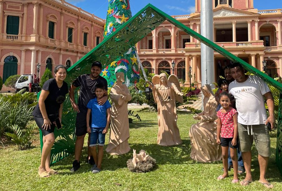 Ciudadanos posan junto a los adornos navideños del Palacio de Gobierno. Foto: Agencia IP.