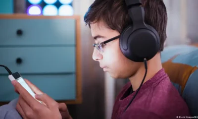 Joven escuchando auricular. Foto: DW.