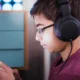 Joven escuchando auricular. Foto: DW.