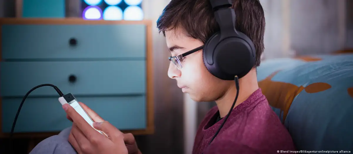 Joven escuchando auricular. Foto: DW.