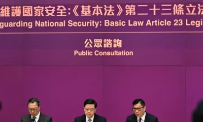 El director ejecutivo de Hong Kong, John Lee (centro), el secretario de Justicia, Paul Lam (izquierda), y el secretario de Seguridad, Chris Tang (derecha), celebran una conferencia de prensa en la sede del gobierno hongkonés. Foto: DW.