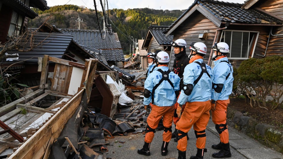 Bomberos inspeccionan casas de madera colapsadas en Wajima, el 2 de enero de 2024, tras el terremoto que azotó la prefectura japonesa de Ishikawa. Foto: AFP.