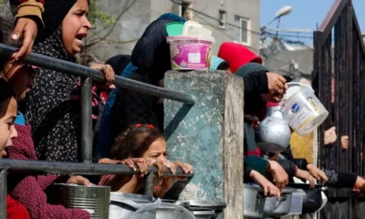 Un grupo de niños espera comida en una cocina comunitaria en Gaza. Foto; DW.