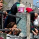 Un grupo de niños espera comida en una cocina comunitaria en Gaza. Foto; DW.