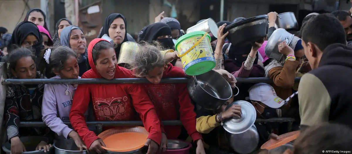 Niños y adultos tratan de conseguir alimentos en la Franja de Gaza. Foto: DW.