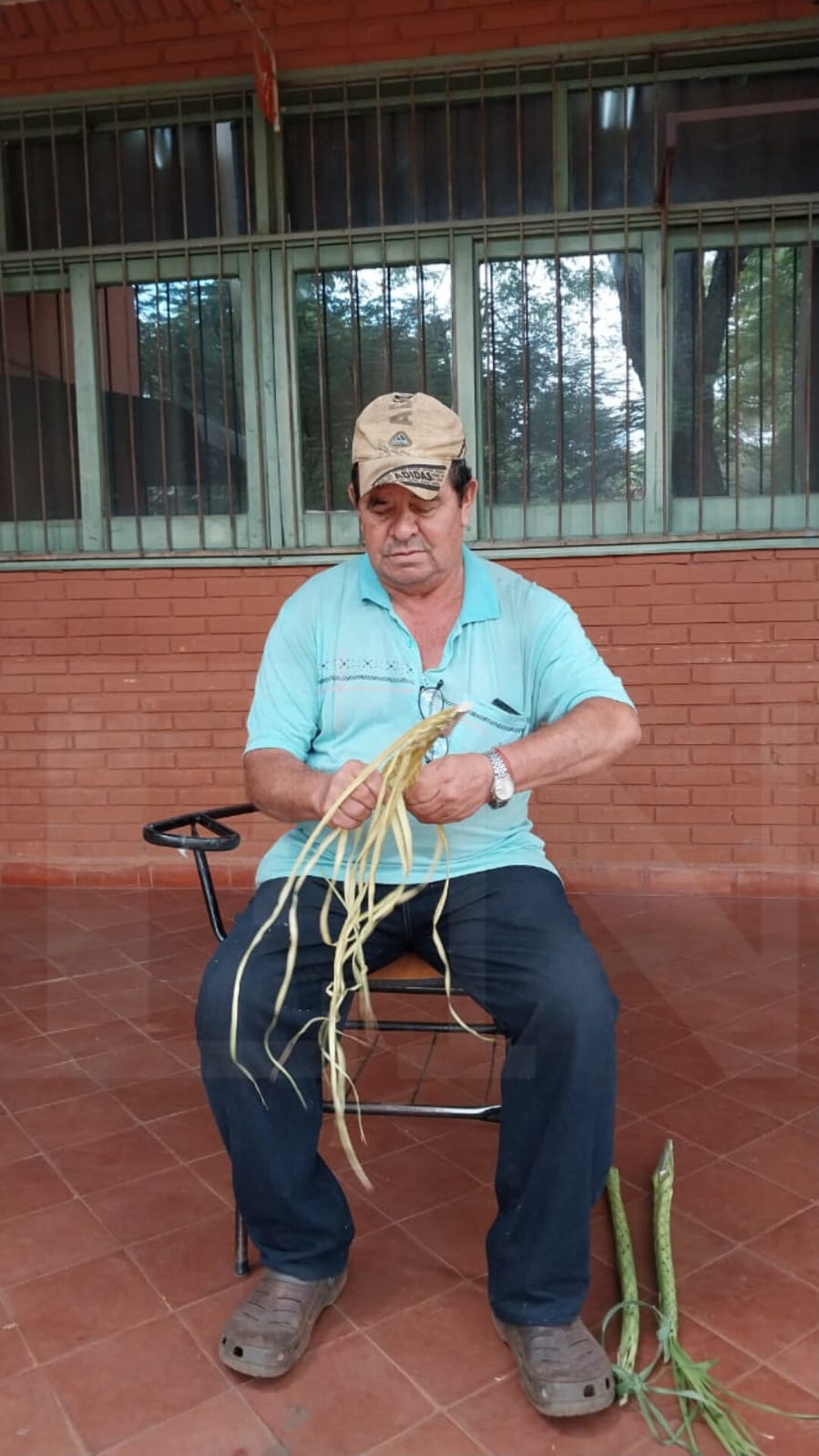 Hombre tejiendo las hojas de pindó. Foto: Lidia Perez de Molas.