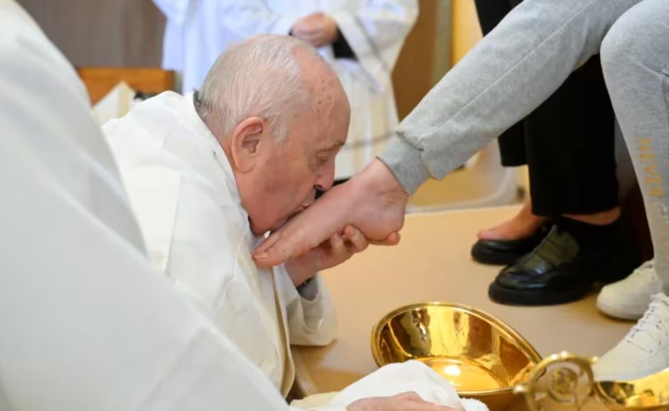 El papa Francisco besa los pies de una reclusa de la sección femenina de la prisión de Rebibbia durante un ritual de Jueves Santo, en Roma, Italia. Foto: Infobae.