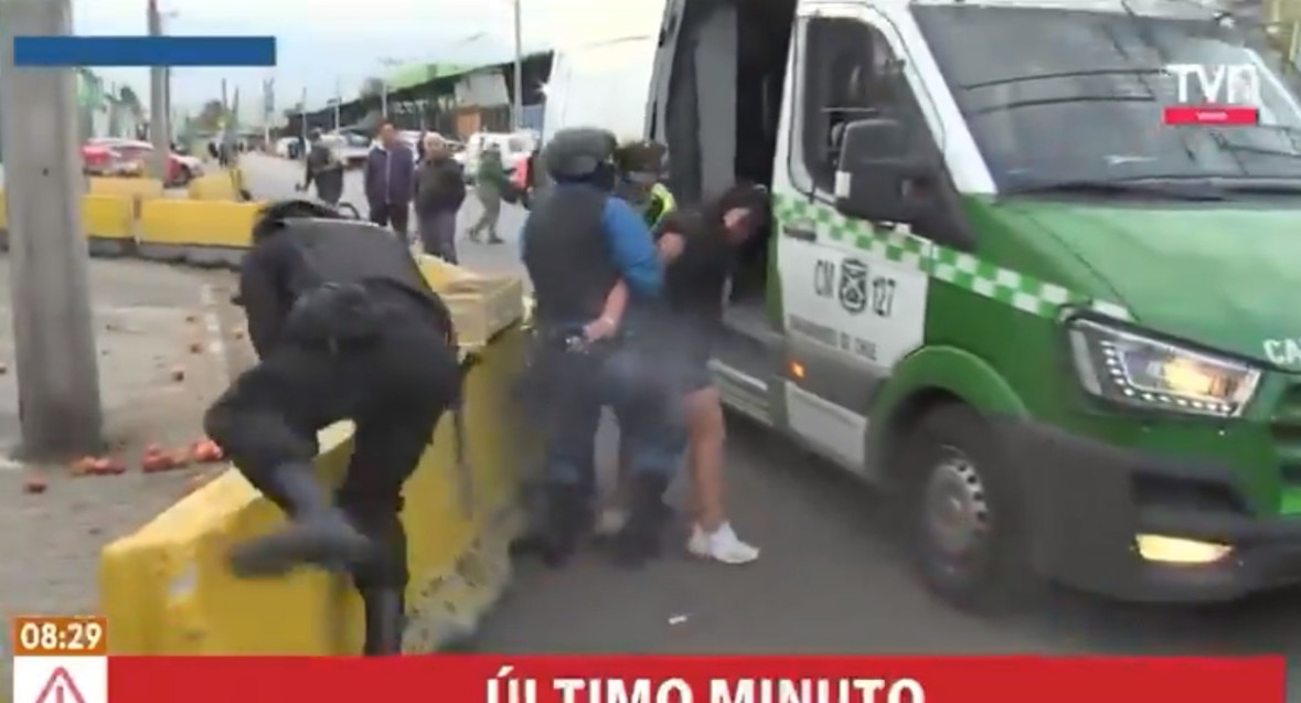 Momento en que la mujer toma el arma del policía y empieza a disparar. Foto: Captura.