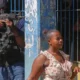 Mujer pasa frente a la vacía Prisión Nacional en Puerto Príncipe, Haití mientras un agente apunta con una metralleta sobre la cabeza de la transeúnteImagen: Odelyn Joseph/AP/